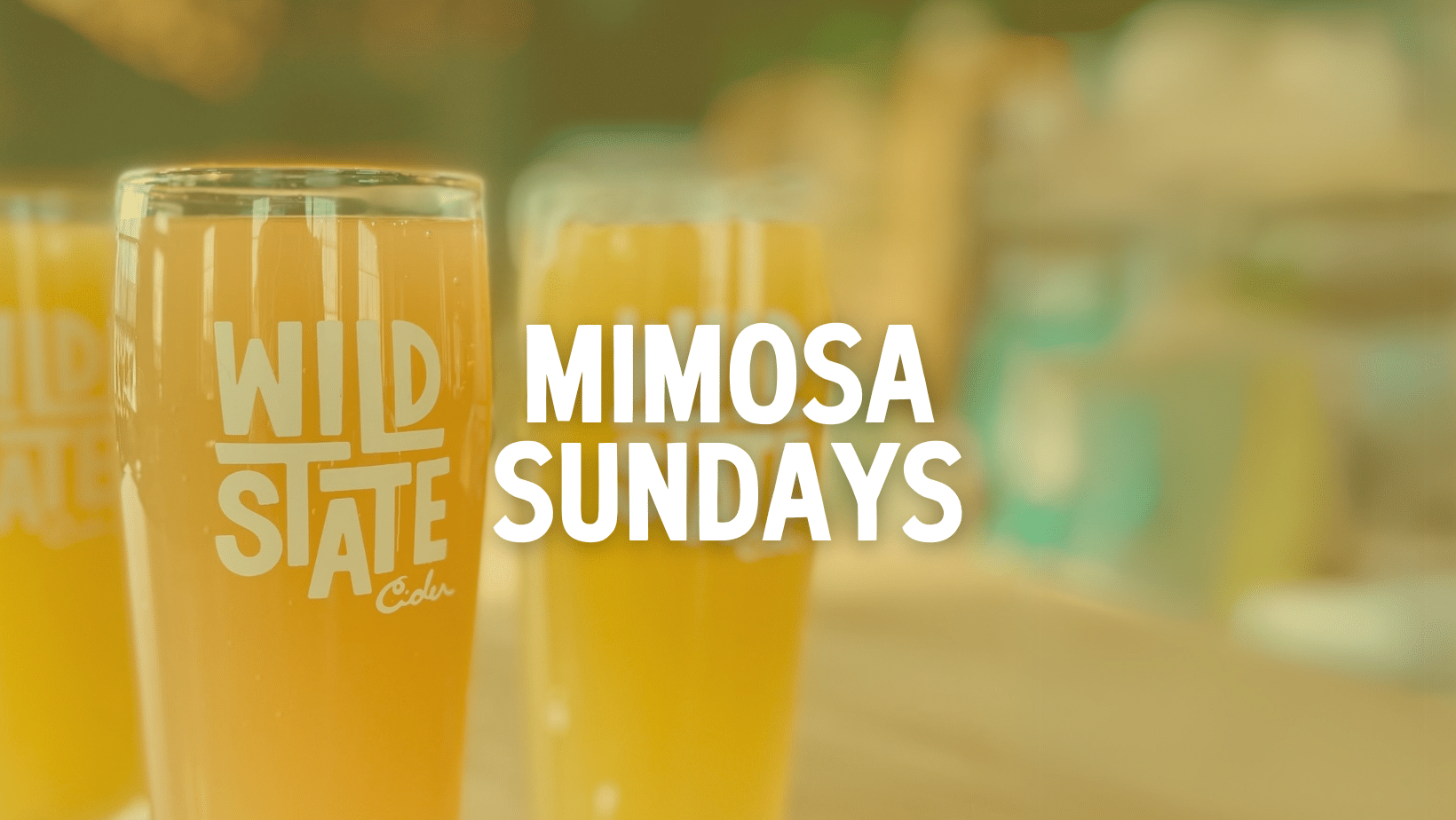 pint glass of mimosa with text reading 'mimosa sundays'